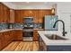 Well-equipped kitchen featuring wood cabinets, stainless steel appliances, and a stylish backsplash at 2853 Yosemite St, Denver, CO 80238