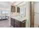 Updated bathroom features a sink with storage beneath, updated fixtures, and a view to the bedroom at 14300 E Marina Dr # 512, Aurora, CO 80014