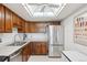 Kitchen with stainless steel fridge and wood cabinets under a light fixture at 14300 E Marina Dr # 512, Aurora, CO 80014