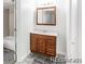 A cozy bathroom features a wooden vanity, mirror and shower-tub combination with a neutral color palette at 1723 Robb St # 44, Lakewood, CO 80215