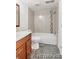 Bathroom showcasing a toilet, shower-tub combination with tiled walls and a vanity at 1723 Robb St # 44, Lakewood, CO 80215