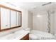 This bathroom features a toilet, a shower-tub combination with tiled walls, a vanity and a mirror at 1723 Robb St # 44, Lakewood, CO 80215