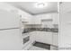 Bright kitchen featuring white cabinets, granite countertops, and stainless steel appliances at 1723 Robb St # 44, Lakewood, CO 80215
