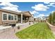 Lush backyard with a covered patio, seating area, and well-manicured lawn, ideal for outdoor activities at 228 Rogers Ct, Castle Rock, CO 80104