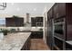 Modern kitchen with stainless steel appliances, granite countertops, and dark wood cabinetry at 228 Rogers Ct, Castle Rock, CO 80104