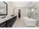 Sleek main bathroom with double vanity, soaking tub, walk-in shower, and neutral tile flooring at 228 Rogers Ct, Castle Rock, CO 80104