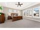 Spacious main bedroom with large windows, tray ceiling, ceiling fan and wood furnishings at 228 Rogers Ct, Castle Rock, CO 80104