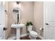 A classic powder room with a pedestal sink, neutral colors, and modern fixtures at 228 Rogers Ct, Castle Rock, CO 80104