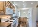 Well-lit kitchen with wood cabinets, white appliances, and hardwood floors for a modern feel at 7971 Larkspur Cir # 219, Frederick, CO 80530