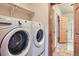 Convenient laundry room featuring a white Whirlpool washer and dryer with a storage shelf above at 7971 Larkspur Cir # 219, Frederick, CO 80530