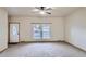 Spacious living room featuring neutral carpet, a ceiling fan and a large window at 7971 Larkspur Cir # 219, Frederick, CO 80530