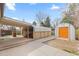 Spacious backyard featuring a covered patio area, storage sheds, and ample room for outdoor activities at 3055 S Winona Ct, Denver, CO 80236