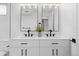 Modern bathroom featuring dual sinks, white cabinets, black fixtures, and stylish globe lighting at 3055 S Winona Ct, Denver, CO 80236