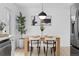 Bright dining area featuring a modern light fixture, seating for four, and stylish decor at 3055 S Winona Ct, Denver, CO 80236