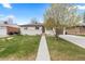 Charming single-story home with a well-manicured lawn and a concrete walkway leading to the front door at 3055 S Winona Ct, Denver, CO 80236
