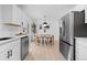 Open kitchen showcasing stainless steel appliances, modern cabinetry, and adjacent dining area at 3055 S Winona Ct, Denver, CO 80236