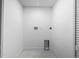 Unfinished laundry area with a new tiled floor and modern hookups at 3055 S Winona Ct, Denver, CO 80236