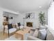 Bright living room with white brick fireplace, light wood floors and contemporary furnishings at 3055 S Winona Ct, Denver, CO 80236