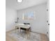 Minimalist office with a white desk, comfortable chair, and a window that provides natural light at 3055 S Winona Ct, Denver, CO 80236