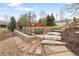 Backyard features a stepped terrace, garden bed, and custom landscaping at 6071 S Detroit St, Centennial, CO 80121