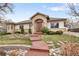 Charming home with a brick-arched entry, manicured landscaping, and a winding walkway at 6071 S Detroit St, Centennial, CO 80121