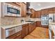 A gourmet kitchen offers wood cabinetry, granite countertops, and stainless steel appliances at 6071 S Detroit St, Centennial, CO 80121