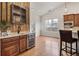 Stylish kitchen features a wine fridge, wooden backsplash, and wood floors at 6071 S Detroit St, Centennial, CO 80121