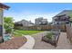 Spacious backyard featuring a garden area, wooden fence, and concrete pathway, surrounded by neighboring homes at 5932 S Versailles St, Aurora, CO 80015