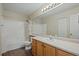 Well-lit bathroom featuring a shower-tub combination, wide mirror, and laminate flooring at 5932 S Versailles St, Aurora, CO 80015
