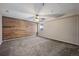 Empty room with wood accent wall and neutral carpet offers versatile space for customization at 5932 S Versailles St, Aurora, CO 80015