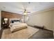 Bedroom with wood accent wall, ceiling fan, and plush rug offers a relaxing retreat at 5932 S Versailles St, Aurora, CO 80015