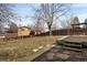 Spacious backyard with a wood deck, fence, mature trees, and stone pavers at 9825 W Walker Pl, Littleton, CO 80123