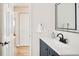 Bathroom featuring a vanity with a blue cabinet and a framed mirror at 9825 W Walker Pl, Littleton, CO 80123