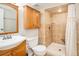 Renovated bathroom features tile shower and wood cabinetry at 9825 W Walker Pl, Littleton, CO 80123
