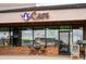 Cafe exterior view with a table and chairs, featuring bright signage and brick facade at 9825 W Walker Pl, Littleton, CO 80123