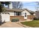 Charming single-story home featuring a brick facade, lush lawn, and inviting landscaping at 9825 W Walker Pl, Littleton, CO 80123