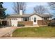 Charming single-story home featuring a brick facade, lush lawn, and inviting landscaping at 9825 W Walker Pl, Littleton, CO 80123