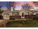 Charming single-story home featuring a brick facade, lush lawn, and inviting landscaping at 9825 W Walker Pl, Littleton, CO 80123