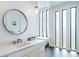 This bright bathroom features a modern vanity, round mirror, soaking tub, and stylish fixtures at 8765 Canyon Wind St, Parker, CO 80138