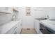 Bright laundry room includes new washer and dryer, white cabinets, and sink at 8765 Canyon Wind St, Parker, CO 80138