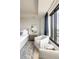 Comfortable bedroom seating area with a plush armchair and city views from large windows at 1133 14Th St # 2000, Denver, CO 80202