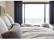 Comfortable bedroom featuring a large window with city views and cozy bedding at 1133 14Th St # 2000, Denver, CO 80202