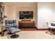 Comfortable living area with a gray recliner, wooden floors, and a large flatscreen TV for relaxing evenings at 1133 14Th St # 2000, Denver, CO 80202