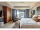 Spacious bedroom features a large window, wood wardrobes, and comfortable seating area at 1133 14Th St # 2000, Denver, CO 80202