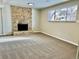 Inviting living room featuring a classic brick fireplace and a large window for natural light at 7460 W Bails Ave, Lakewood, CO 80232