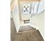 Carpeted staircase leading to a white door with decorative glass, complemented by a white railing at 7460 W Bails Ave, Lakewood, CO 80232