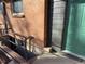 Exterior shot showcasing basement access with safety rail, brick facade and green door at 9962 W 77Th Ave, Arvada, CO 80005