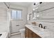 Bathroom with marble countertop, subway tile, and updated vanity at 9962 W 77Th Ave, Arvada, CO 80005