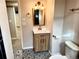 Updated bathroom features a wood vanity, stylish tile, and modern fixtures at 9962 W 77Th Ave, Arvada, CO 80005