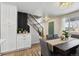 Cozy dining area with modern chandelier, view into the updated kitchen, and stylish staircase at 9962 W 77Th Ave, Arvada, CO 80005